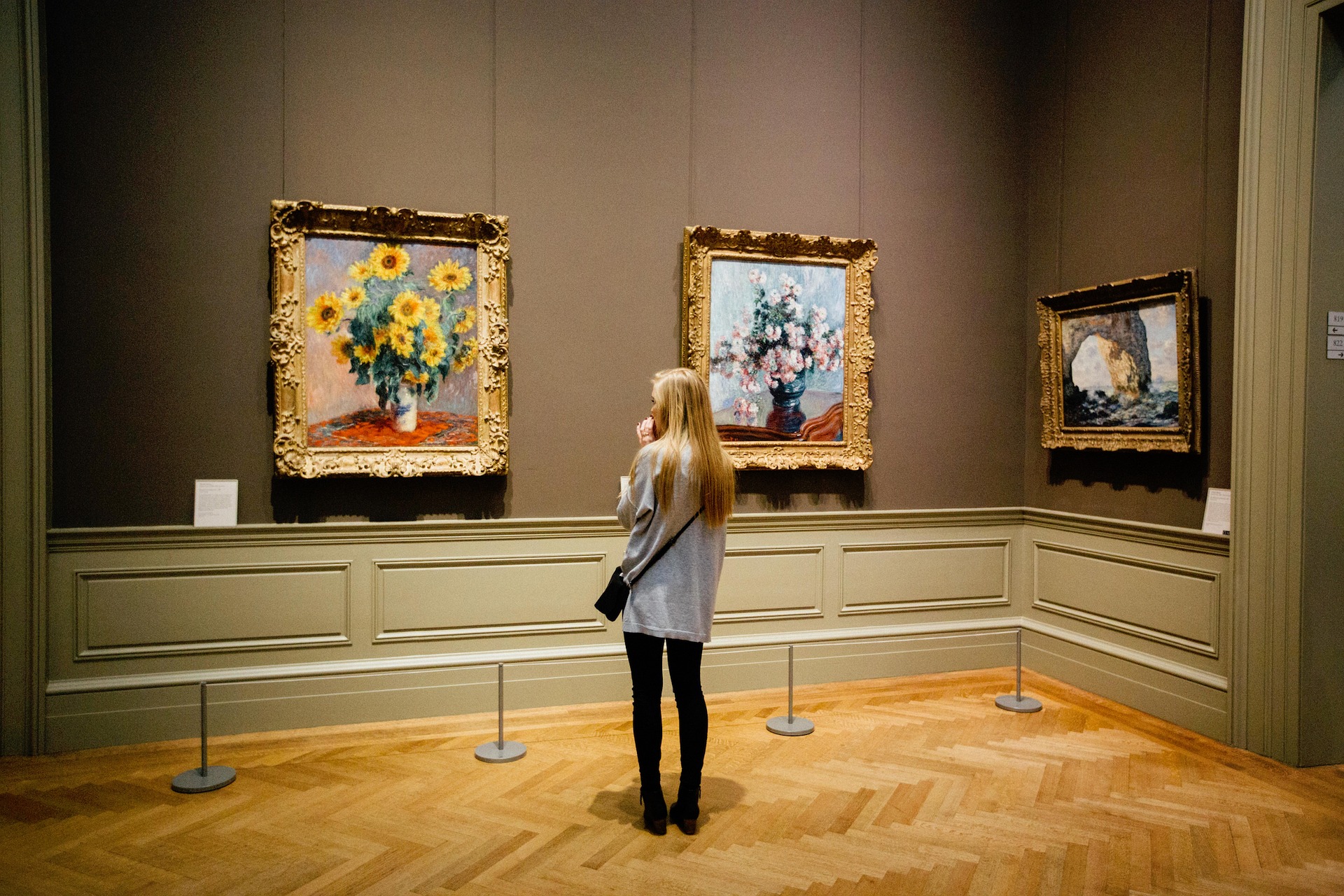 vrouw die in museum naar kunst kijkt