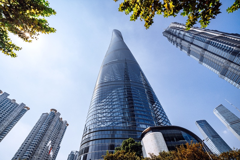 Dynamic view of Shanghai's iconic skyscraper rising into a clear blue sky